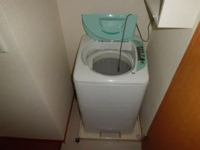 洗濯機。横には洗剤等が置ける棚あり。
