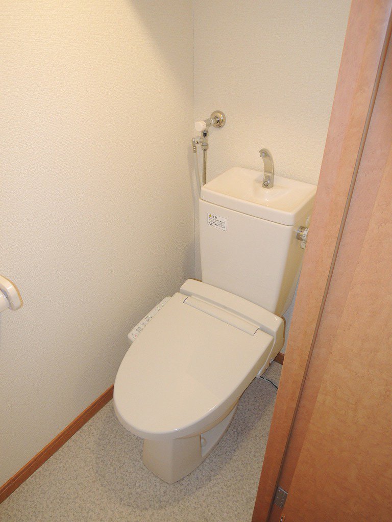 温水洗浄便座。トイレットペーパーなどの収納棚もございます。