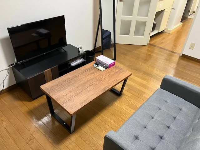TV、ローテーブル、ソファー、姿見があります。