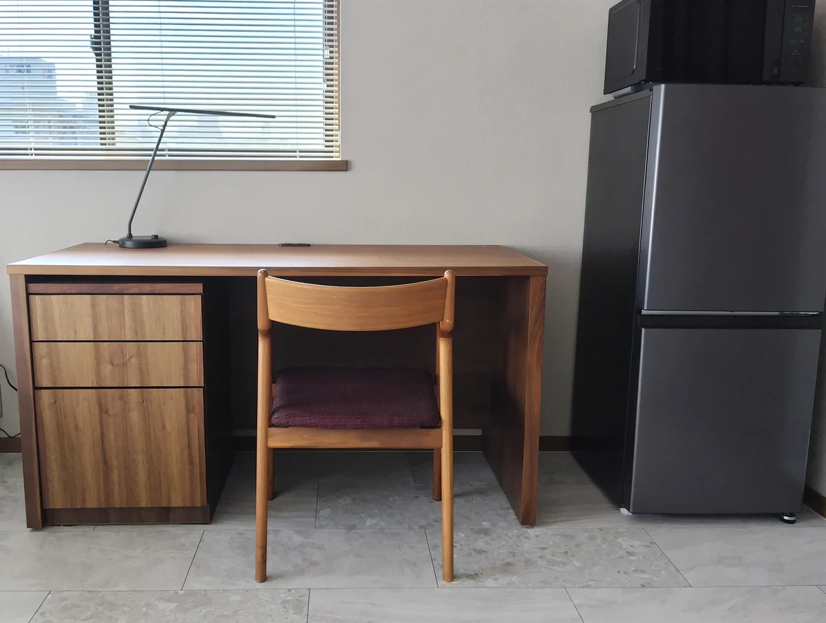 ウォールナットのデスクはW1400×D600、デスクランプは山田照明のZライトで調色調光タイプ