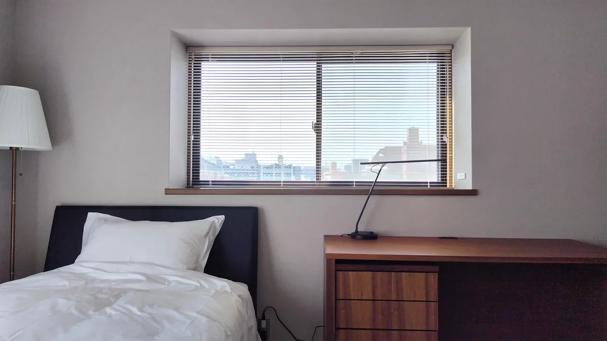 ベッドもデスクもゆったりサイズ。壁クロスは落ち着いたベージュ