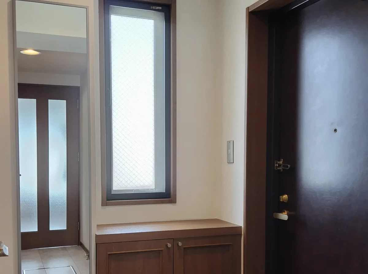 窓があって明るい玄関、姿見とコンパクトなシューズボックス