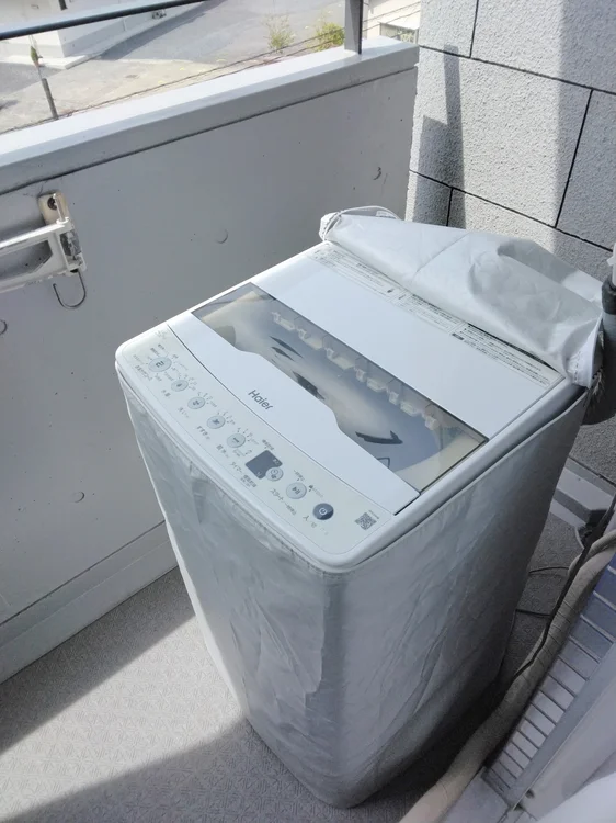ベランダに洗濯機設置。洗濯カゴあります。
