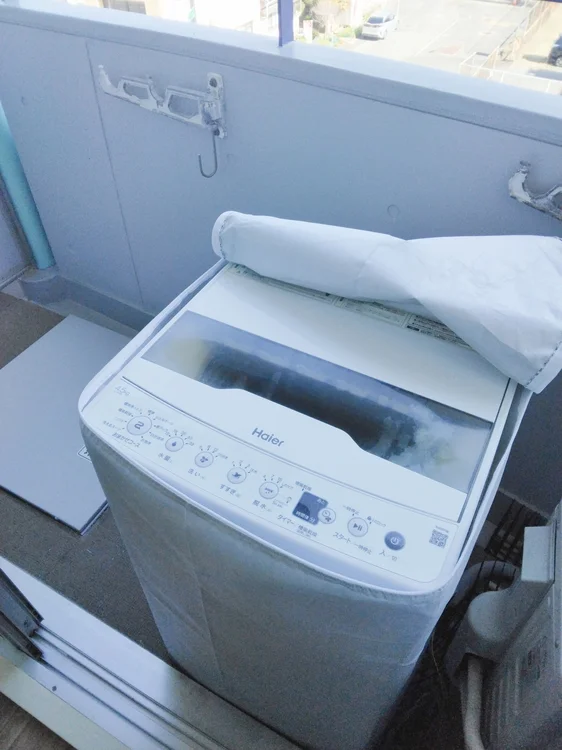 ベランダに洗濯機設置。洗濯カゴあります。
