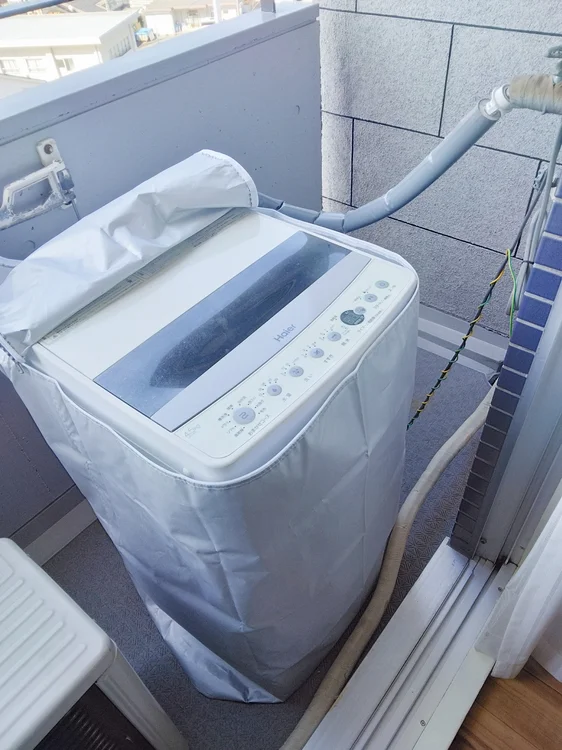 洗濯機ベランダに設置。洗濯カゴあり。