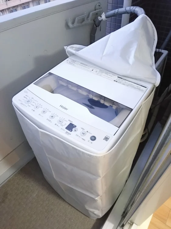洗濯機ベランダに設置。洗濯機カゴあり。
