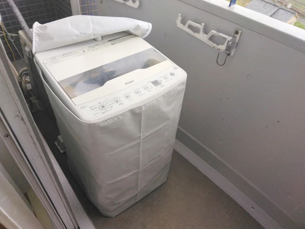 洗濯機ベランダに設置。洗濯機カゴあり。