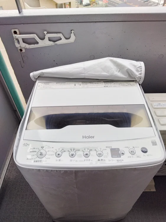 ベランダに洗濯機あり。洗濯カゴあります。