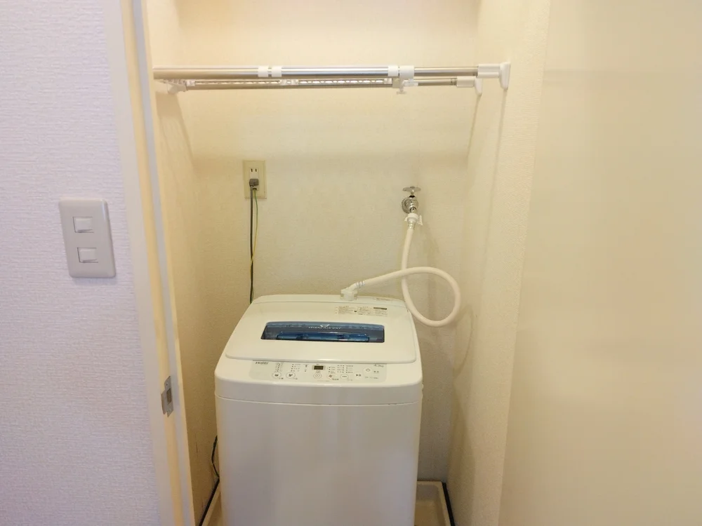 室内洗濯機、洗濯機の上に収納棚・洗濯物入れカゴあり。