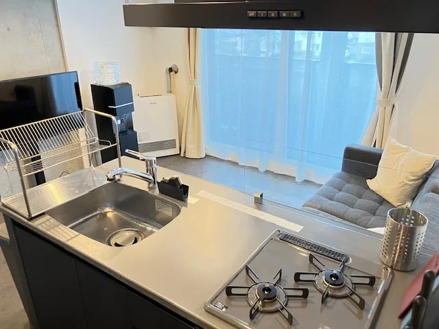 対面キッチンで開放感のある空間。2口ガスコンロ付きで自炊もしやすく、長期滞在でも快適にお過ごしいただけます。