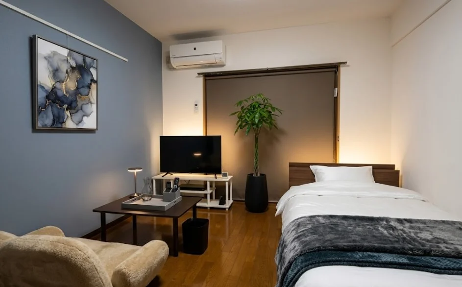 仕切りを最小限に抑え、視覚的な広がりを追求。専有面積以上のゆとりを感じさせる設計で、長期滞在でも圧迫感なくお過ごしいただけます。※植木と額とクッションなどは写真用です。