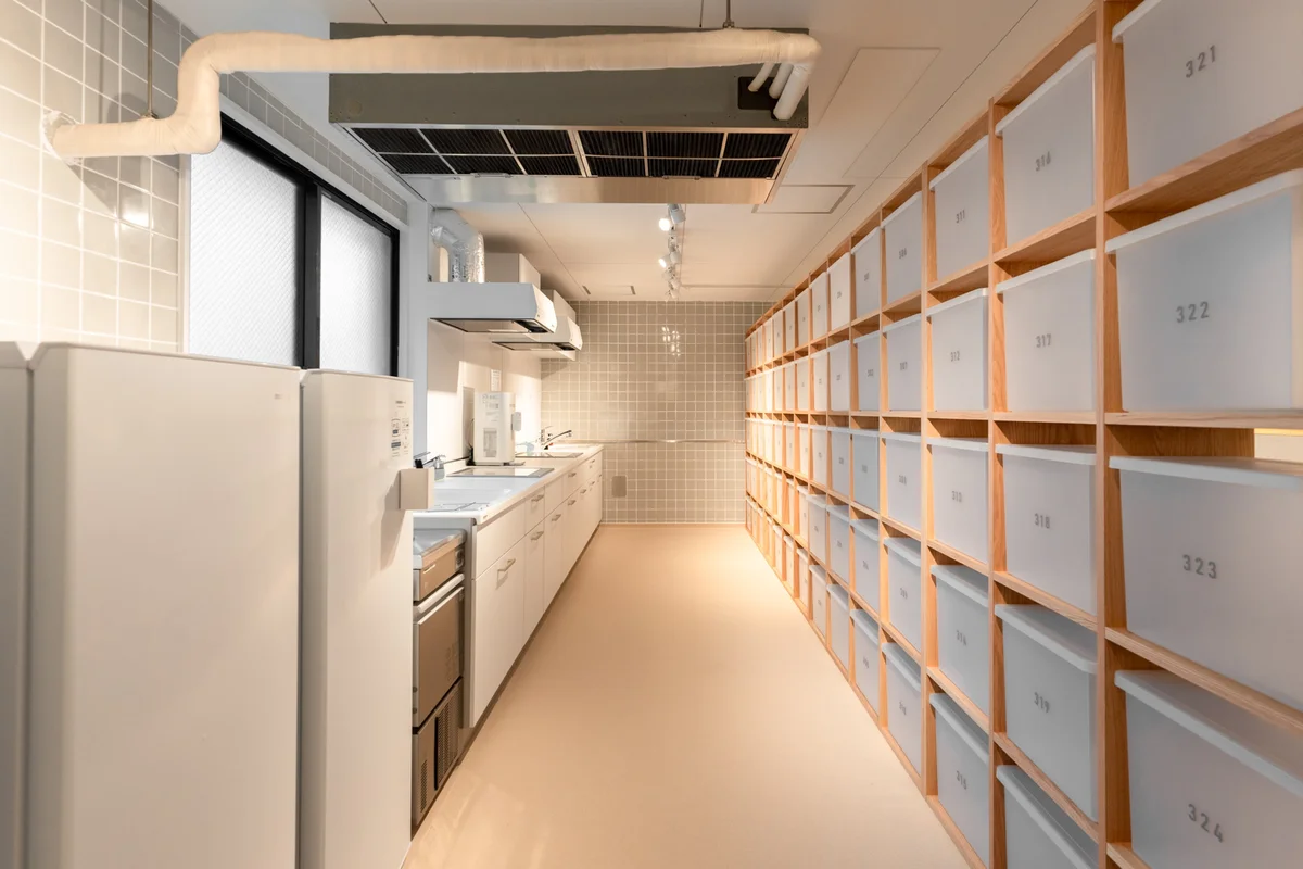 キッチンの横には共用の冷凍庫、背面には各お部屋ごとのストッカーが。