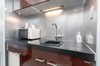 ミニキッチンには電子レンジ、湯沸かしポット、小さなシンク付き。あたたかいごはんを室内で。