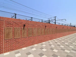 カープ記念碑ロード　JR広島駅南口からマツダスタジアムまでの線路沿いに、赤い道が続きます。徒歩約10分の道のりが「カープロード」と呼ばれています。道路脇のフェンスには選手紹介だけでなく、OBやスタジアム紹介などのパネルが連なっています。