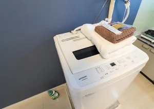 室内に設置された全自動洗濯機。コインランドリーへ行く手間と時間を削減し、自分のペースで家事を完結できる自由を提供します。