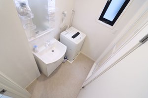 忙しい朝のルーティンをスムーズにするシャワー付き独立洗面化粧台。大型ミラーと歯ブラシ・コスメ類を置けるサイドトレイを備え、ビジネス前のヘアセットやスキンケアをストレスなく行えます。廊下の一角に全自動洗濯機を完備。共用ランドリーへ行く手間や小銭を用意するストレスがなく、深夜や早朝でも天候に左右されずプライベートな空間で気兼ねなく洗濯が完結します。