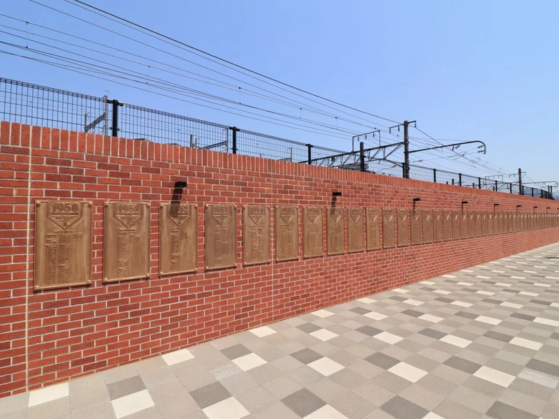 カープロード　JR広島駅南口からマツダスタジアムまでの線路沿いに、赤い道が続きます。徒歩約10分の道のりが「カープロード」と呼ばれています。道路脇のフェンスには選手紹介だけでなく、OBやスタジアム紹介などのパネルが連なっています。