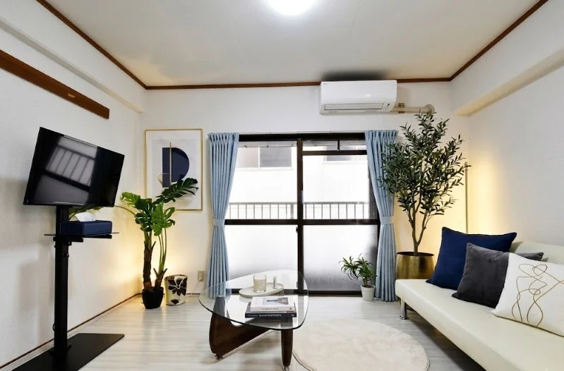 10.5帖広めの白色を基調とした部屋でソファありのマンション！　明るい室内で　大き目のソファあり！　自宅のように寛いでいただけます。※植木と額とクッションなどは写真用です。