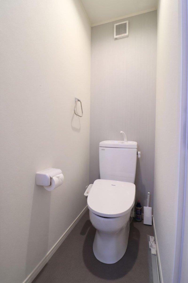 清潔感あふれる独立個室トイレには、快適な温水洗浄便座（ウォシュレット）を標準装備。上部にはトイレットペーパーや衛生用品をすっきりストックできる収納棚を備え、生活感を隠したスマートな空間を保てます。