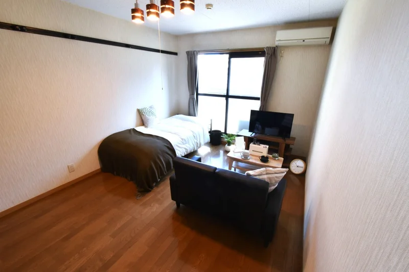 洋室8帖でゆったりと落ち着いた色合いのお部屋！　ソファ付きでテレビを見ながらゆったりとお寛ぎ可能！